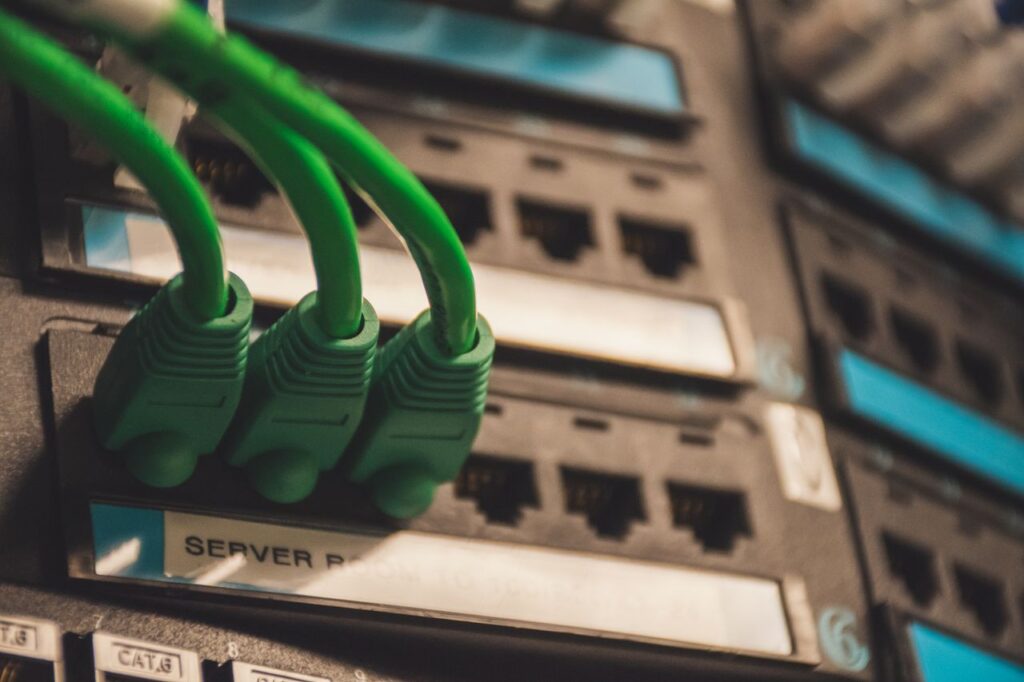 pexels photo 1597776 Close-up of green network cables plugged into server ports, showcasing technology setup.